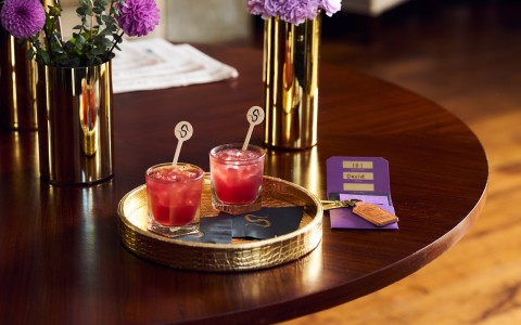 two glasses of red liquid on a round tray main