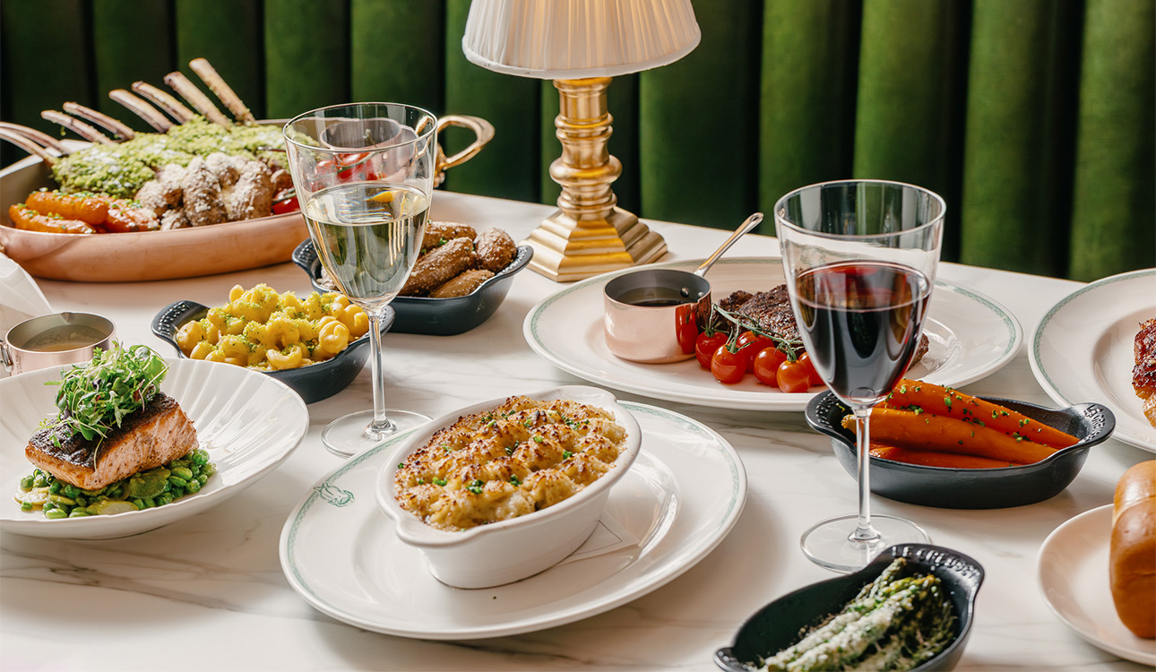 a table with plates of food and wine glasses