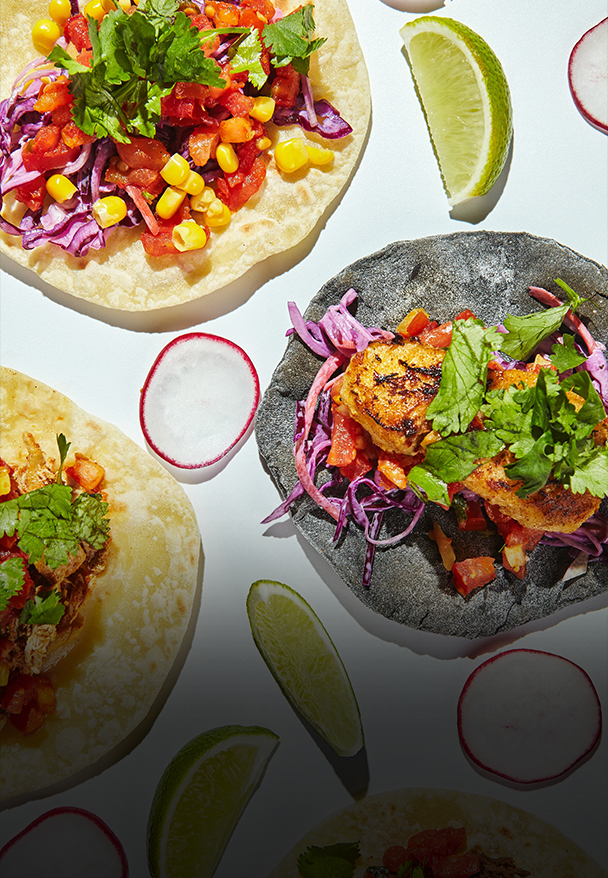 a group of tacos with vegetables and meat