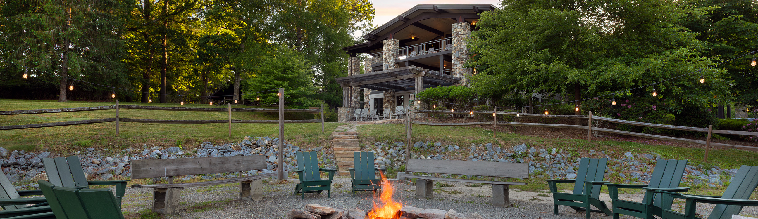 a fire pit with chairs in front of a building