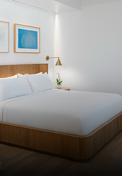a bed with white sheets and a lamp