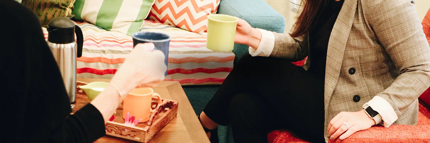 two guests sitting holding cups of coffee