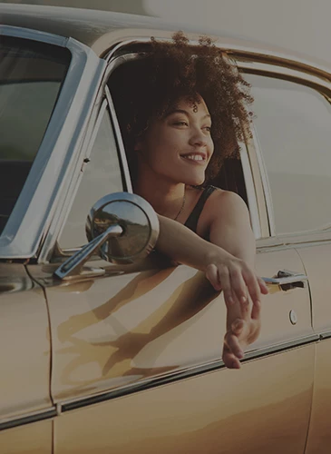 woman in a car window looking through the horizon
