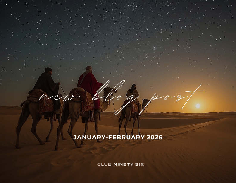 a group of people riding camels in the desert