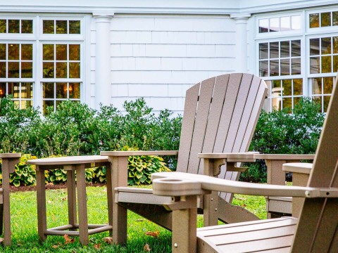 a lawn chair and table in front of a house