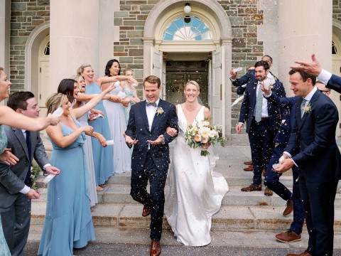 a group of people throwing confetti to a bride and groom