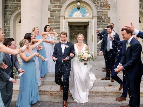 a group of people throwing confetti to a bride and groom