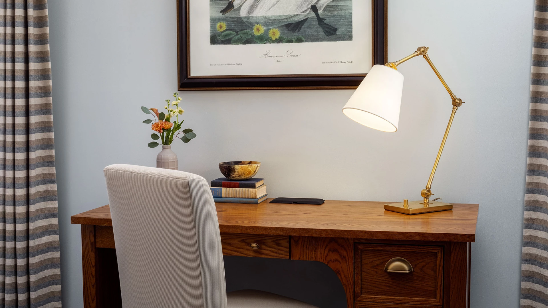 a desk with a lamp and a picture on the wall