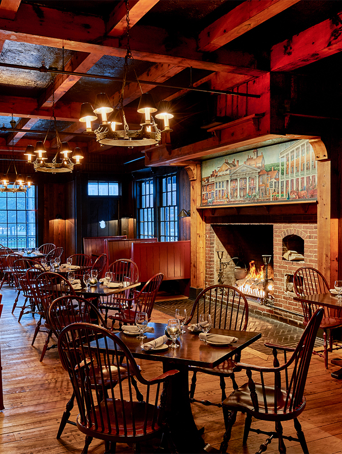 a room with tables and chairs and a fireplace