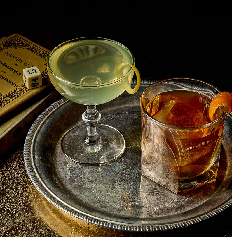 a two glasses of alcohol on a metal tray