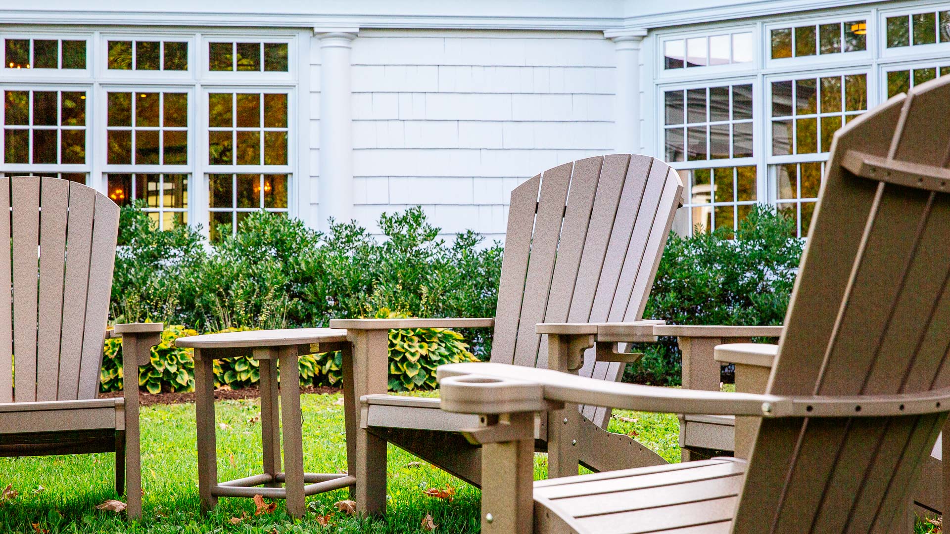 a lawn chair and table in front of a house