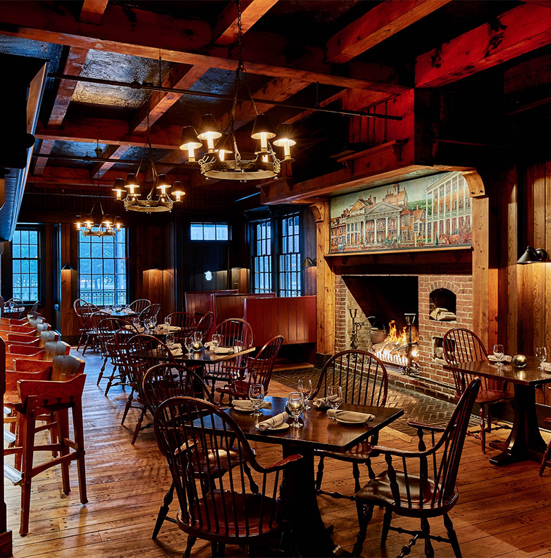 a room with tables and chairs and a fireplace