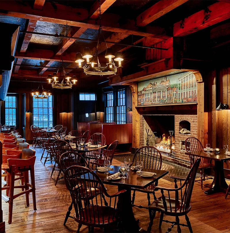 a room with tables and chairs and a fireplace