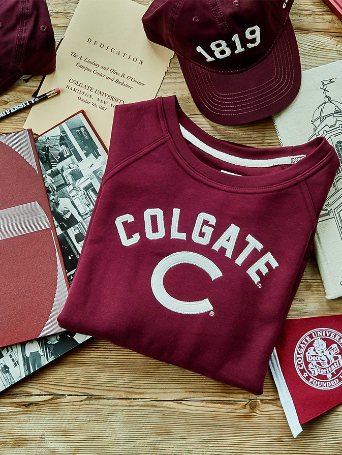 a maroon sweatshirt with white letters on it and a cap on top of it
