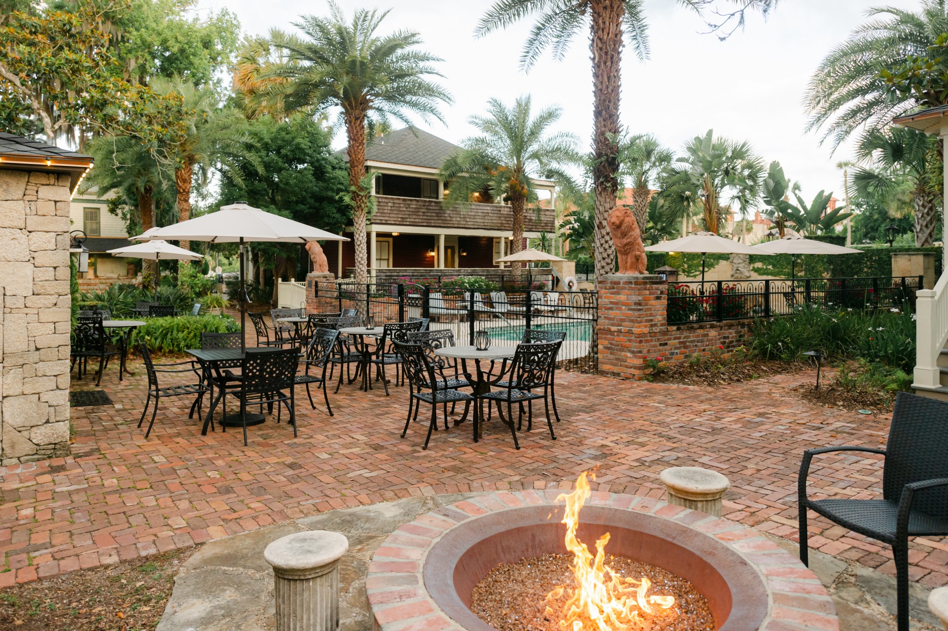 a fire pit with tables and chairs around it