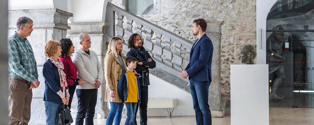 a group of people standing in front of a stone building
