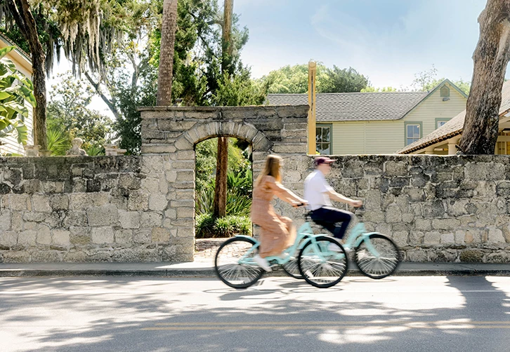 a man and woman riding bicycles on a street