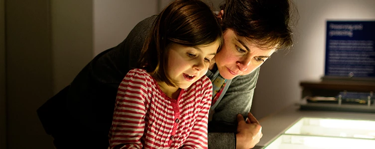 a person and a child looking at a computer screen