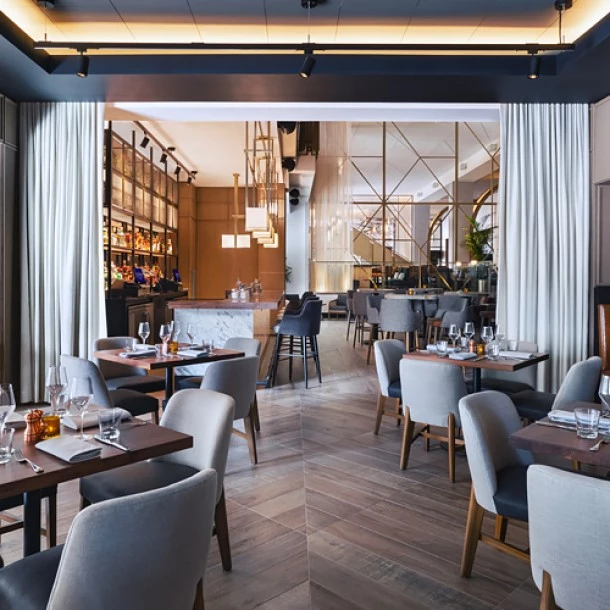 bar and dining area with multiple gray chairs and booths
