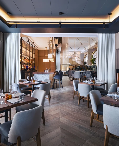 bar and dining area with multiple gray chairs and booths