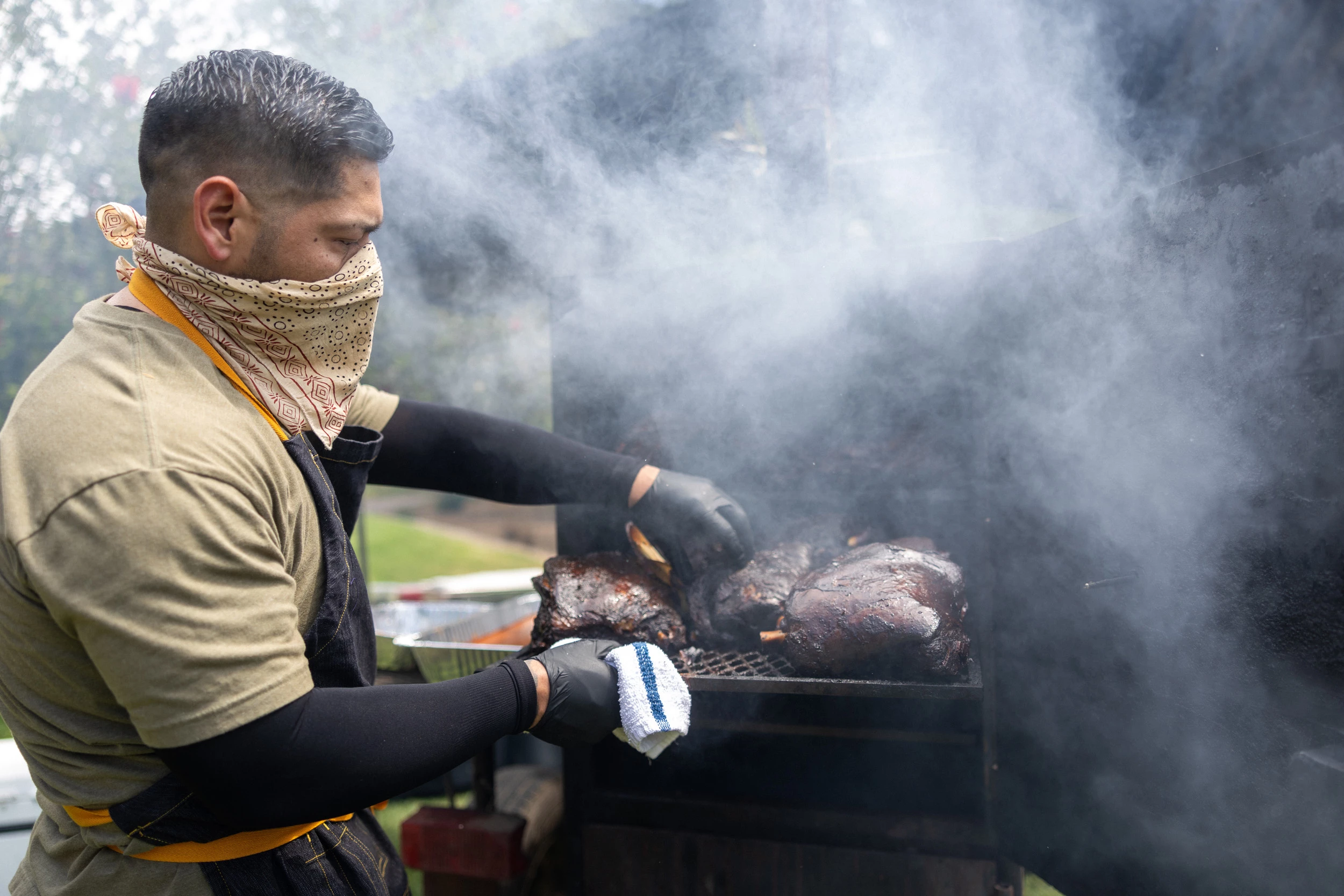 a man cooking meat on a grill