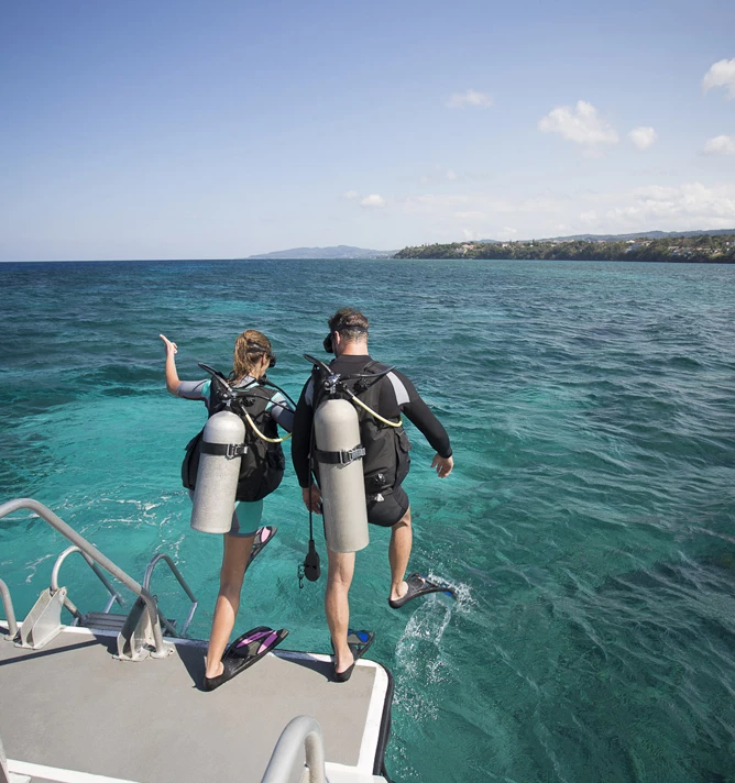 a man and woman in scuba gear on a boat