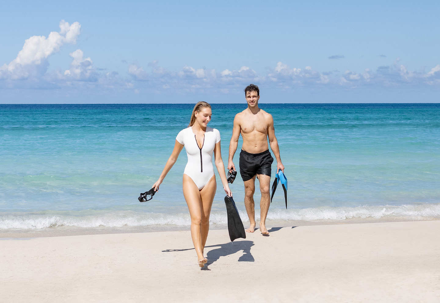 a man and woman walking on a beach