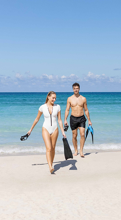a man and woman walking on a beach