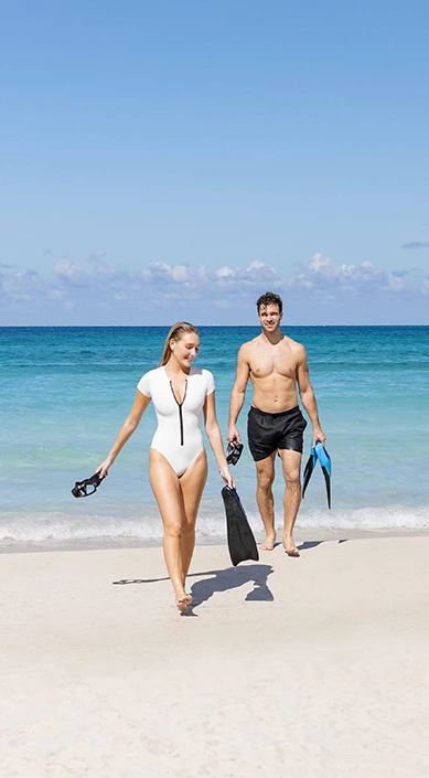 a man and woman walking on a beach