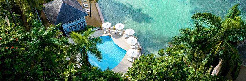 a pool with umbrellas and chairs by the water