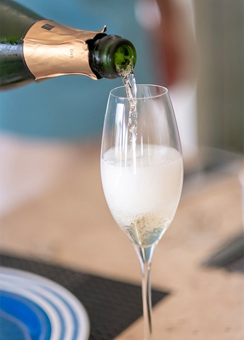 a person pouring champagne into a glass