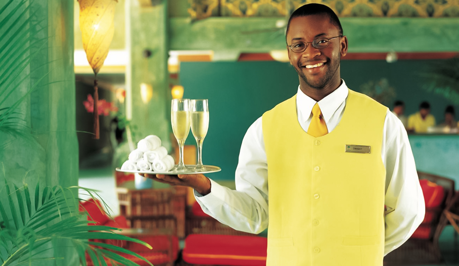 a man holding a tray of champagne