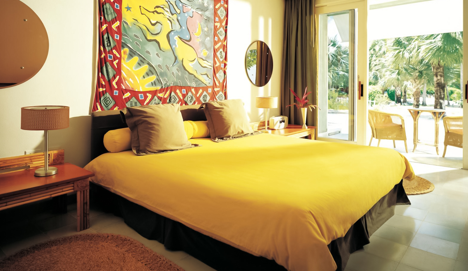 a bed with yellow sheets and pillows