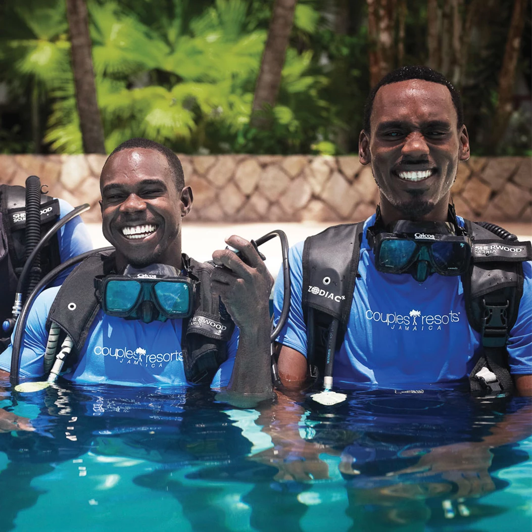 two men wearing scuba gear in a pool