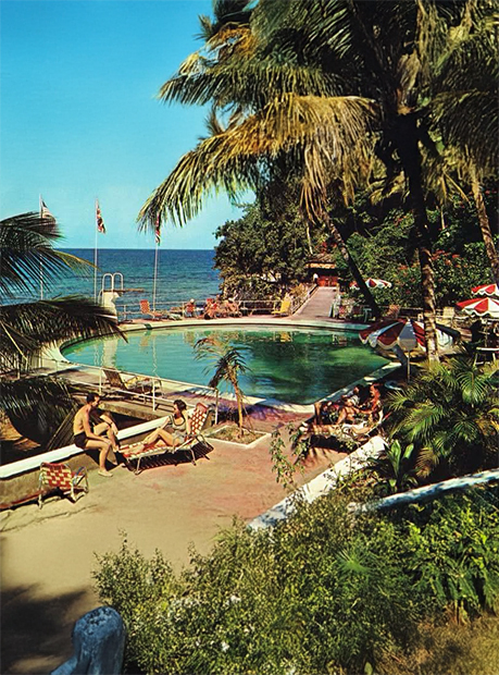 a group of people sitting on lounge chairs by a pool