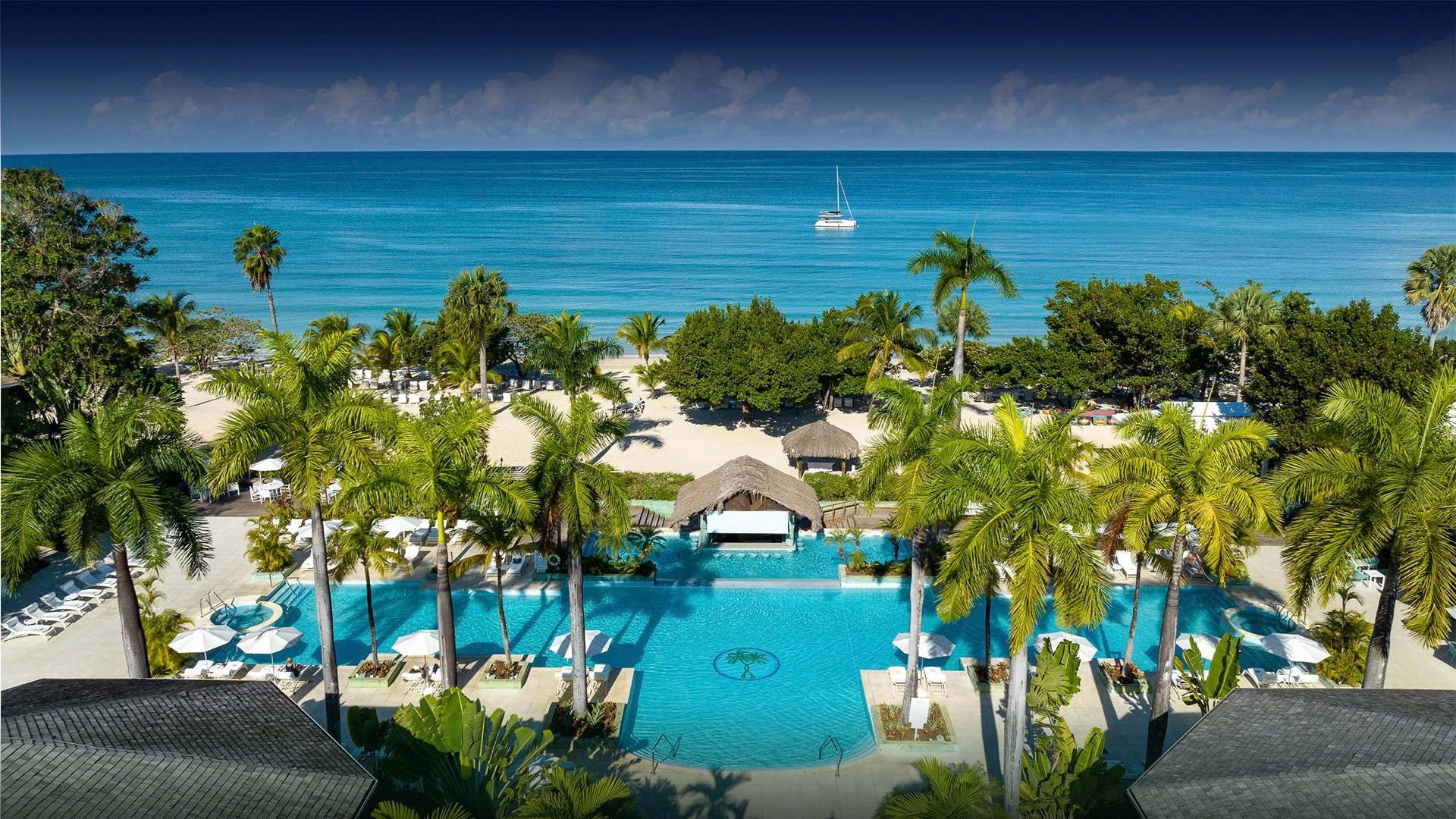 a swimming pool with palm trees and a boat in the water