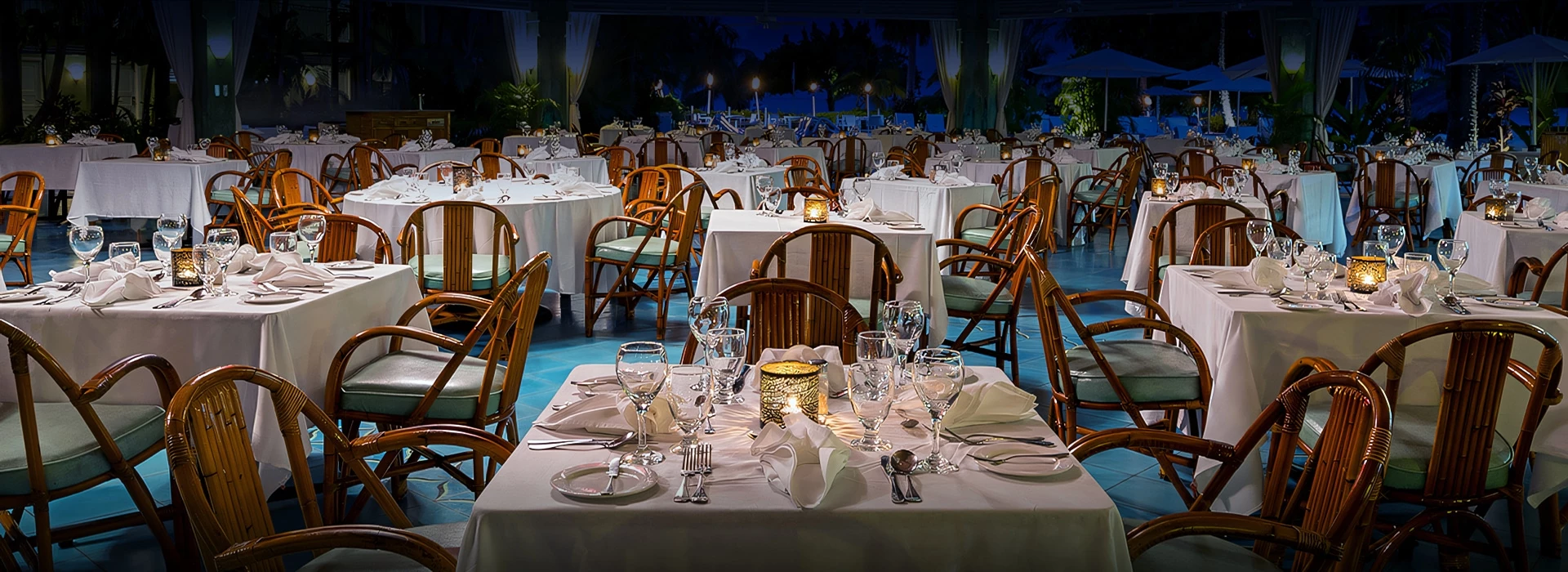 a table set for dinner with white tablecloths and glasses