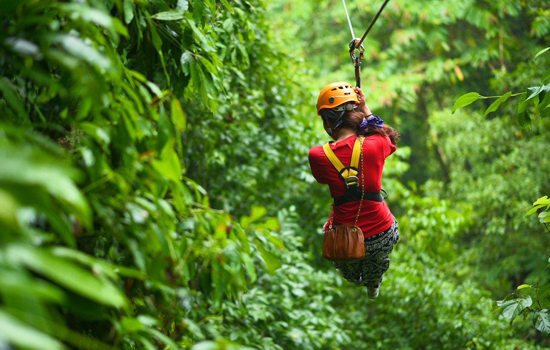 a woman in a helmet from a zip line