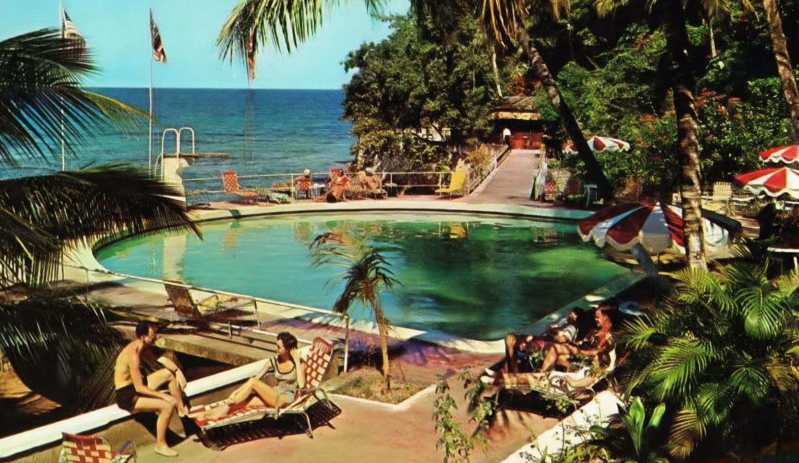 a group of people sitting in chairs near a pool