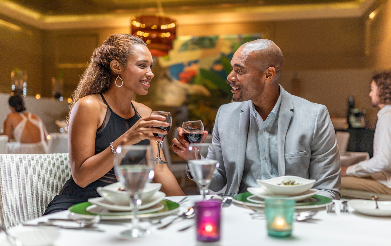 a man and woman sitting at a table with wine glasses
