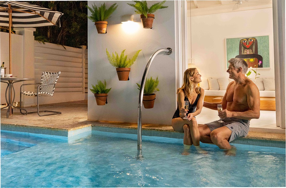 a man and woman sitting on a pool side