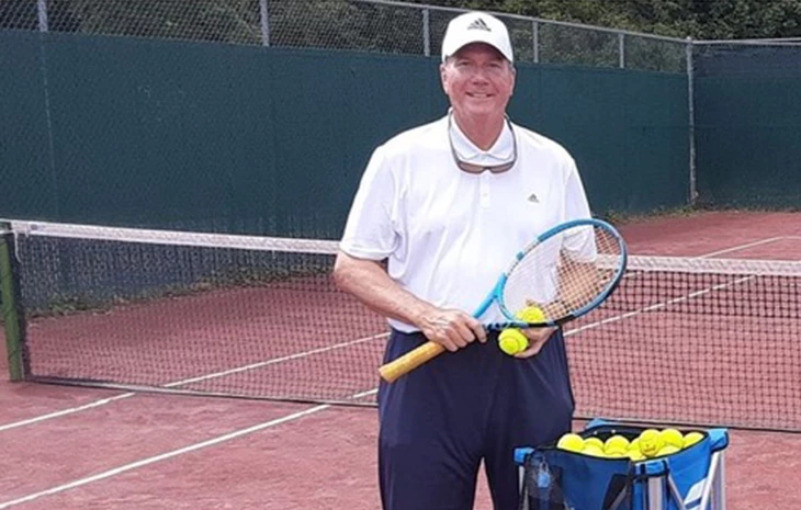 a man holding a tennis racket and balls