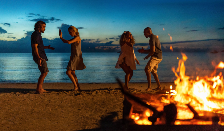 a group of people dancing on a beach
