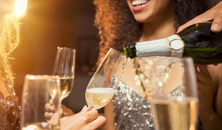 a woman pouring champagne into a glass