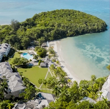 a aerial view of a beach with a body of water and buildings