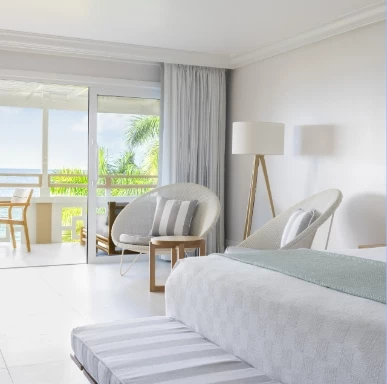 a bedroom with a bed and chairs
