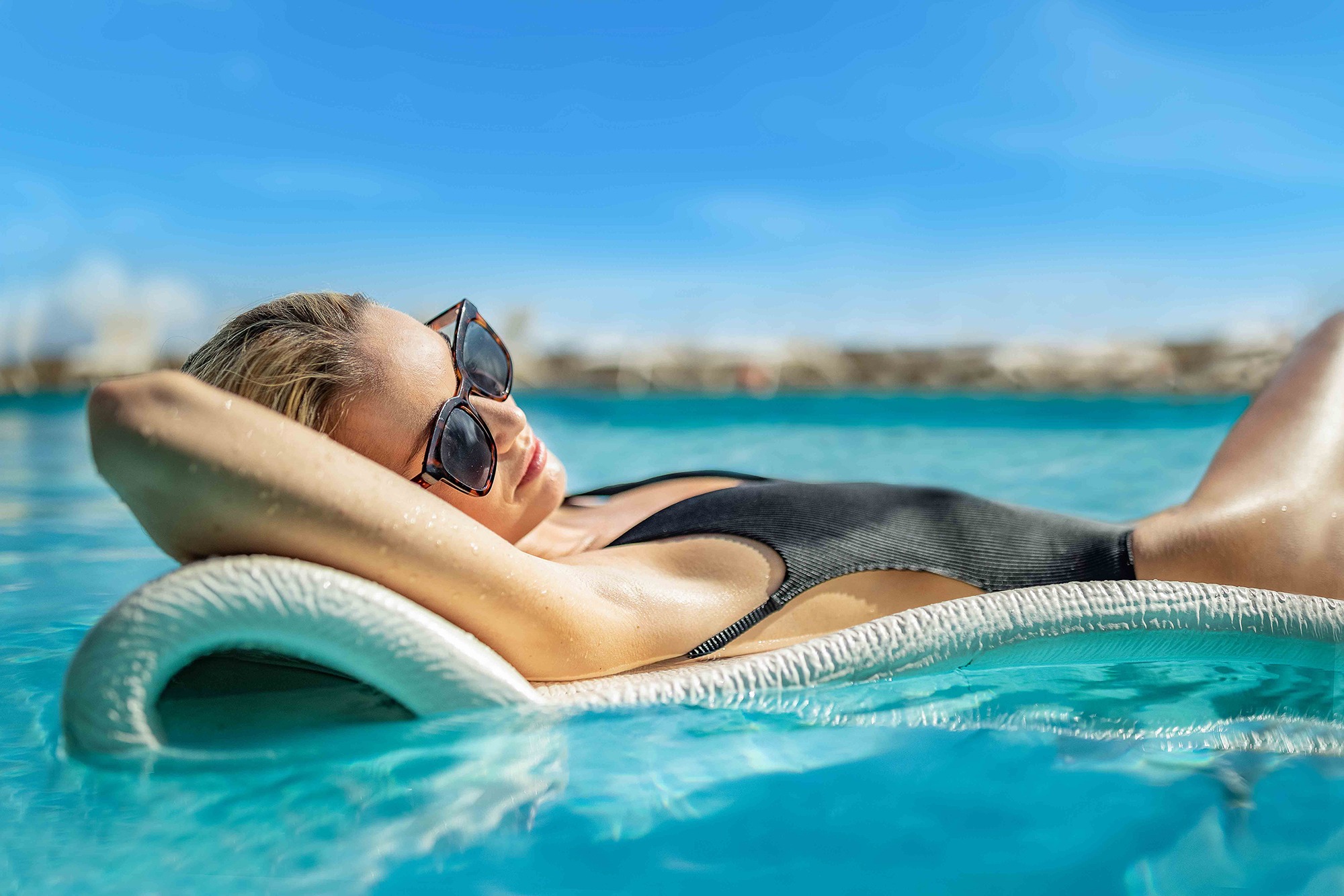 a woman lying on a floating chair in a pool