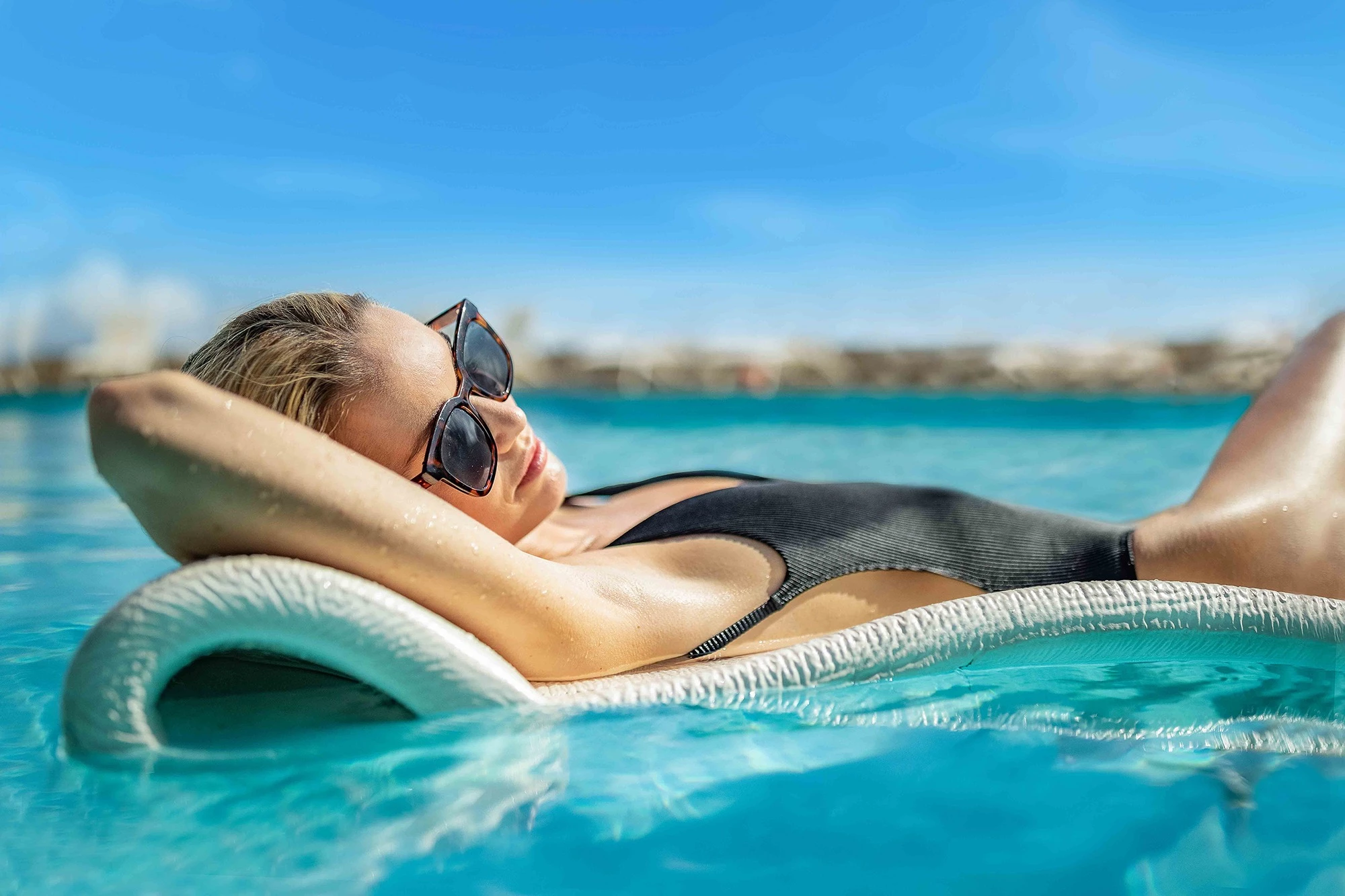 a woman lying on a floating chair in a pool