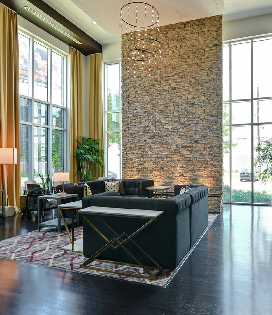 a room with a stone wall and couches