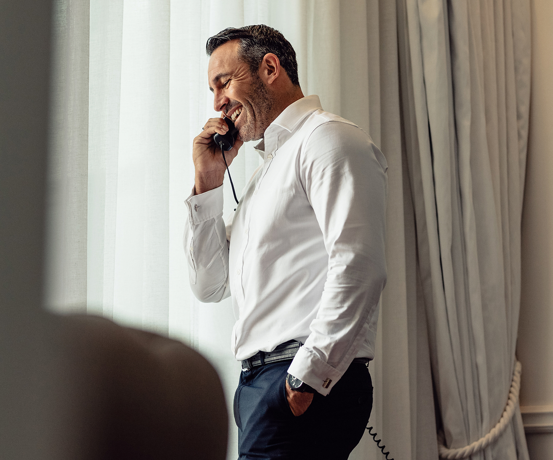 a man in a white shirt talking on a phone